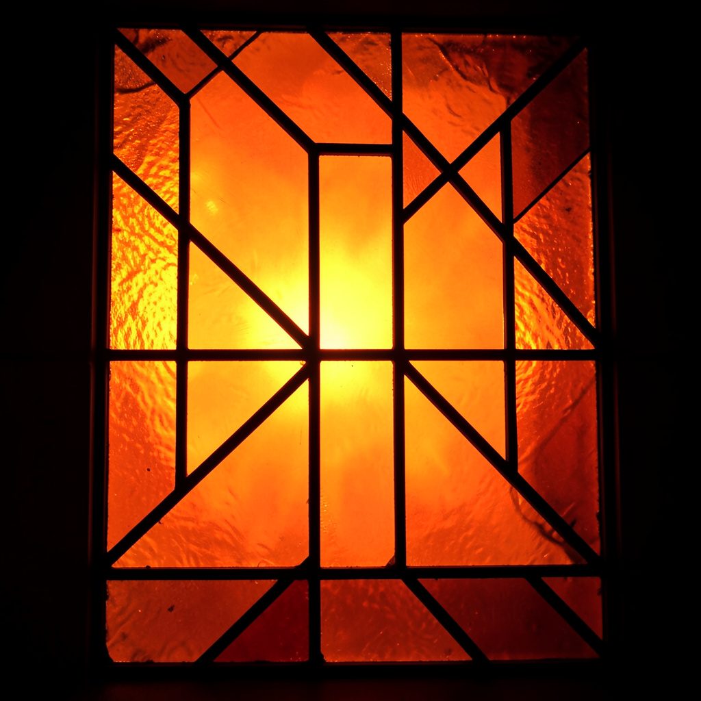 Vintage film projector with reels, glowing amber tones, casting a beam of light, nostalgic mood